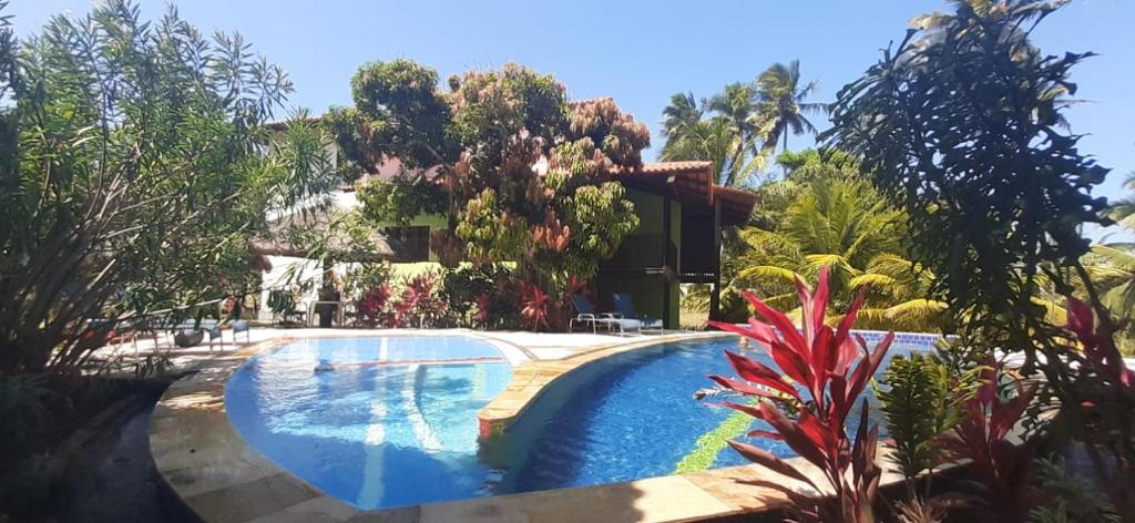 a swimming pool in front of a house at Ecolodge Batel Alagoas in Coruripe