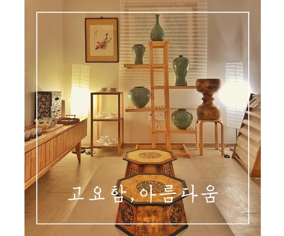 ソウルにあるK-culture Houseの花瓶、テーブル、棚付きの部屋