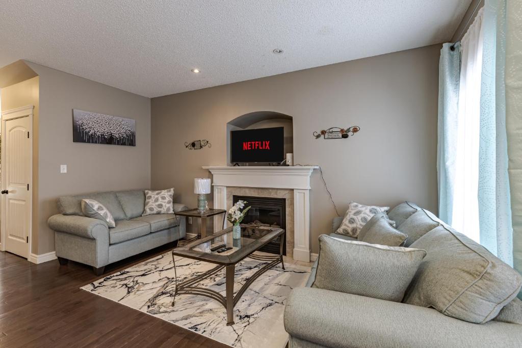 a living room with a couch and a fireplace at Lux-Rooms in Allard Edmonton in Edmonton