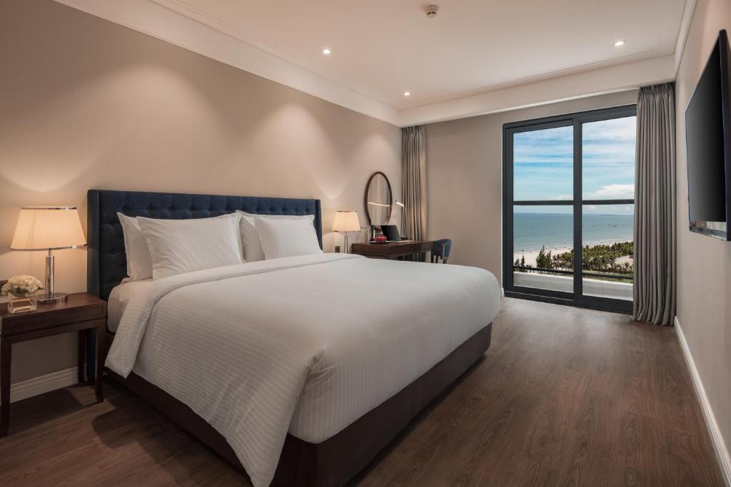 a bedroom with a large bed and a large window at Luxury Apartment with Ocean View - 1 minute to beach in Da Nang