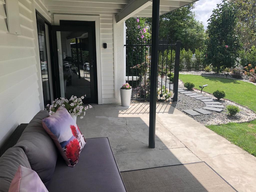 a couch sitting outside of a house at Vista - touch of country and spa in Havelock North