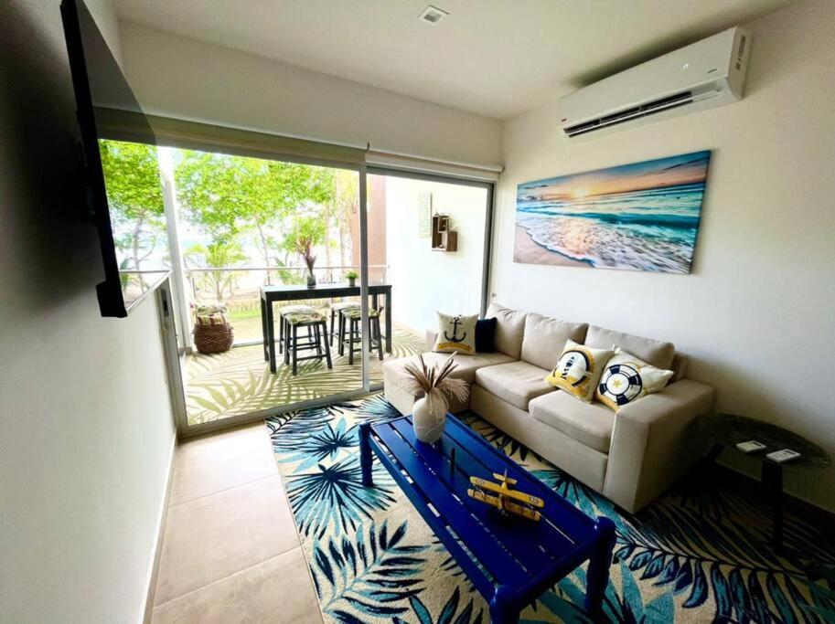 a living room with a couch and a table at 2 Bedroom Oceanfront Condo with Wi-Fi, AC and Pool in Parrita