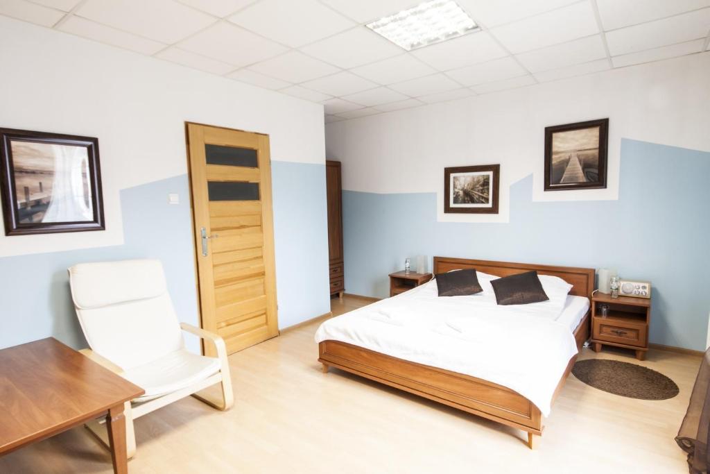 Motel Te Klimaty في تشيلادز: غرفة نوم بسرير ومكتب وكرسي