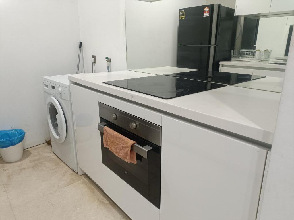 una cucina bianca con piano cottura e lavastoviglie di vortex klcc RR a Kuala Lumpur