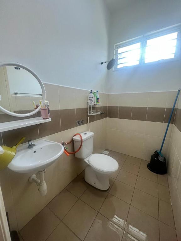 een badkamer met een toilet, een wastafel en een spiegel bij Homestay Denai Universiti near UMK 3 rooms aircond with wifi in Bachok