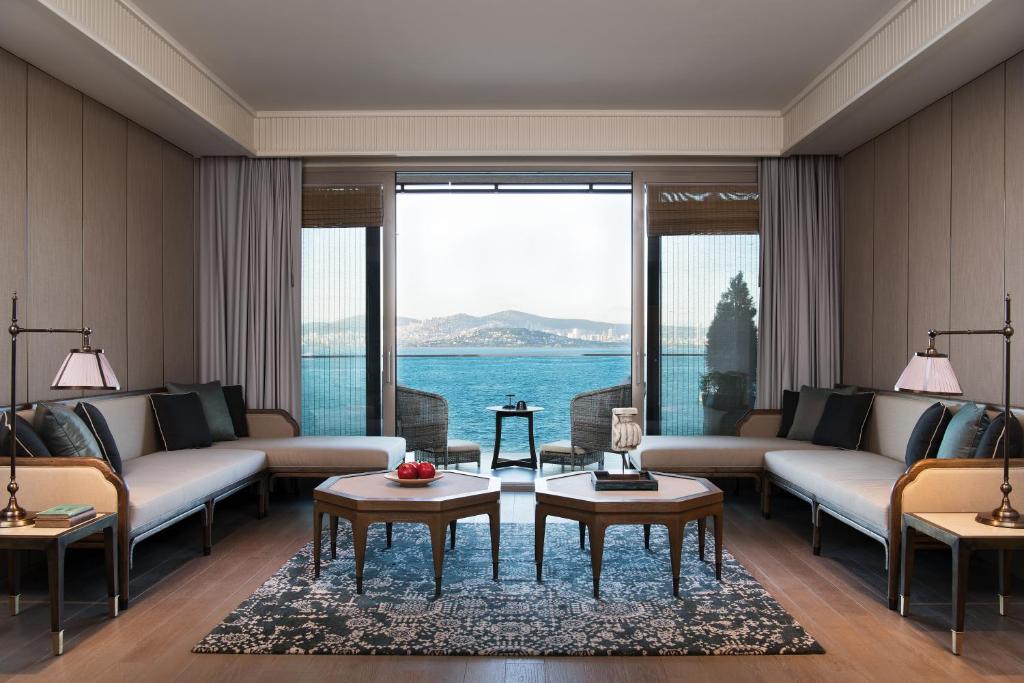 a living room with couches and a view of the water at Princes' Palace Resort, Buyukada in Adalar