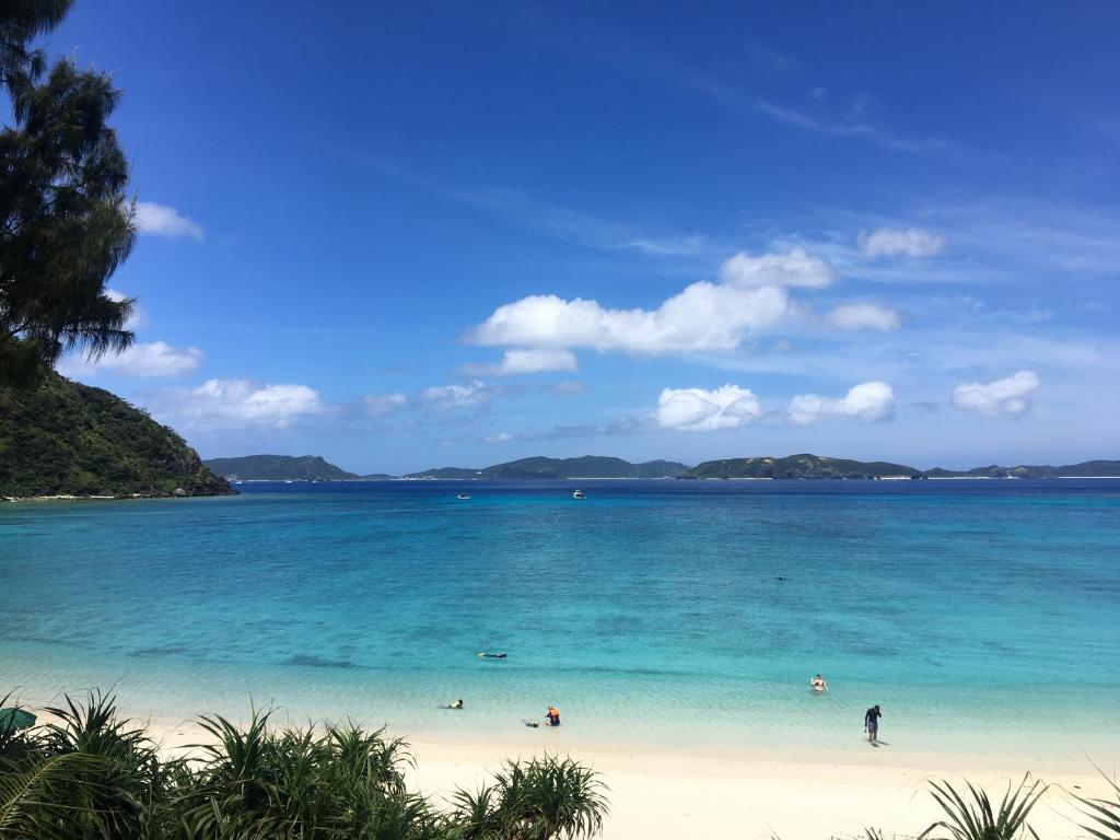 a view of a beach with people in the water at HOTEL KANALOA in Tokashiki