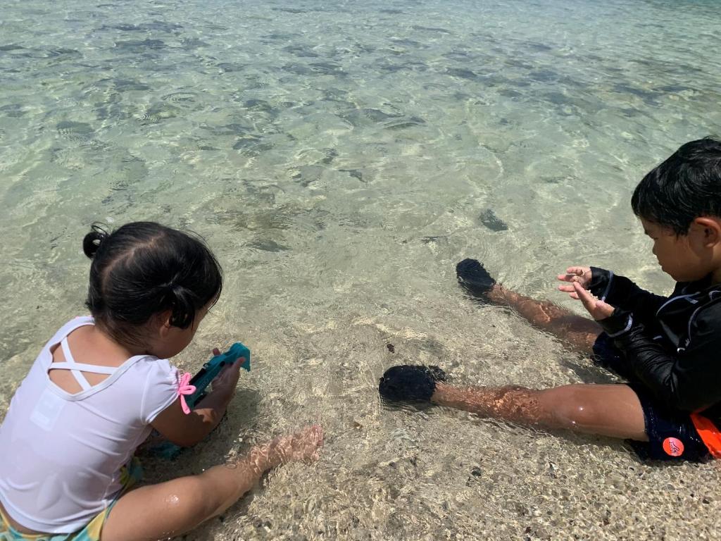 two children playing in the water at the beach at HOTEL KANALOA in Tokashiki