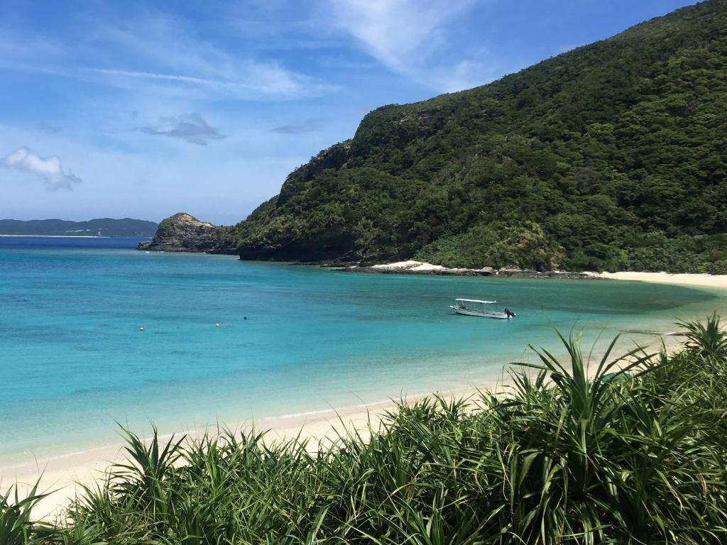a boat in the water on a beach at HOTEL KANALOA in Tokashiki