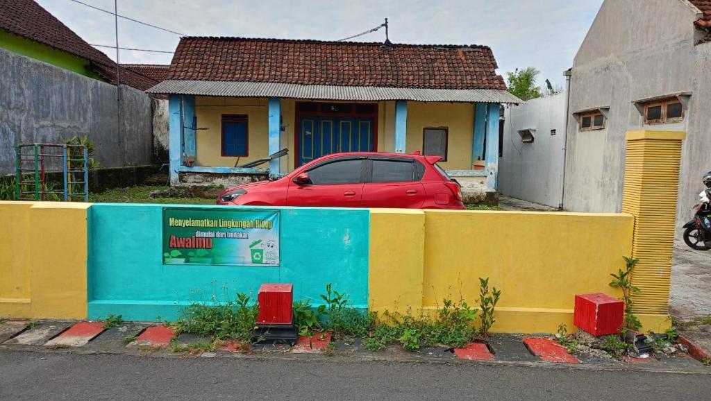 a red car parked in front of a house at SPOT ON 93712 Vanda Family in Blitar