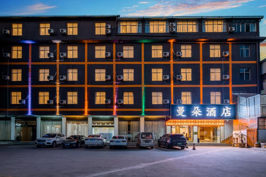un edificio con coches estacionados frente a él en Mando Hotel - Kunming Changshui International Airport, en Kunming