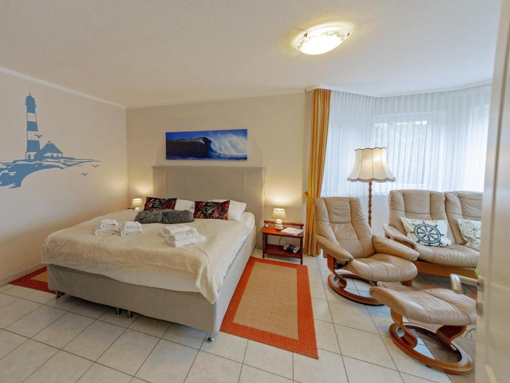 ein Schlafzimmer mit einem Bett, einem Sofa und einem Stuhl in der Unterkunft Ferienhaus Binz - Apt. 02 in Binz