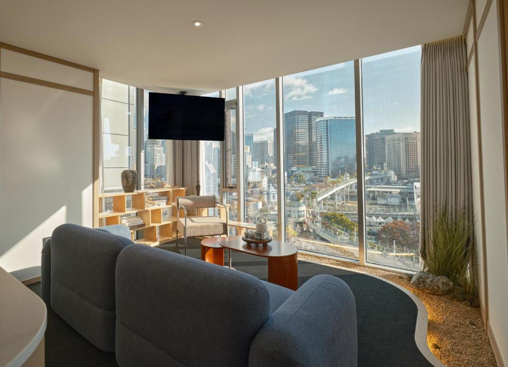 a living room with a couch and a large window at UH Suite The Seoul in Seoul