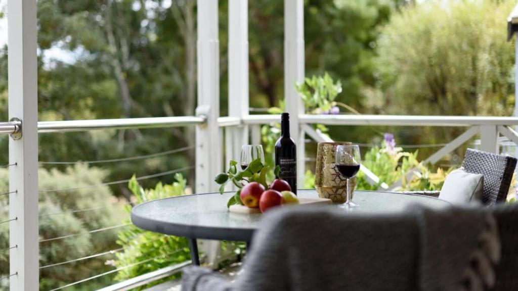 a table with a glass of wine and some fruit at Lakeside Suite 2 - Lake View & Spa Bath in Daylesford