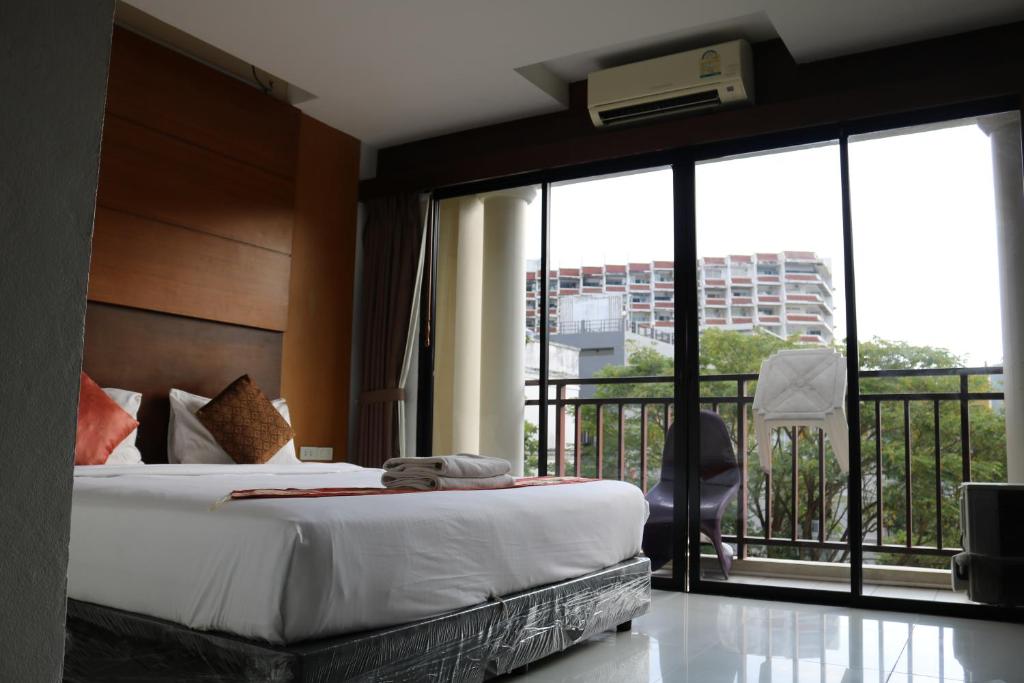 a hotel room with a bed and a balcony at Diamond Crown in Patong Beach