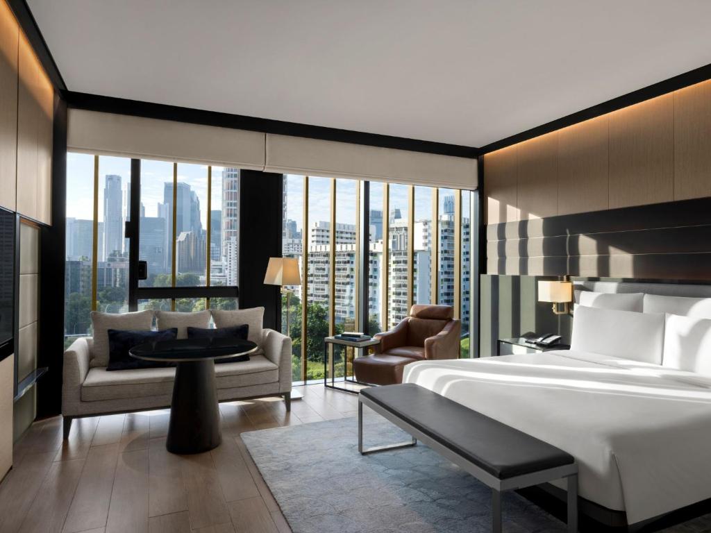 Cette chambre comprend un lit et une grande fenêtre. dans l'établissement InterContinental Singapore Robertson Quay, an IHG Hotel, à Singapour