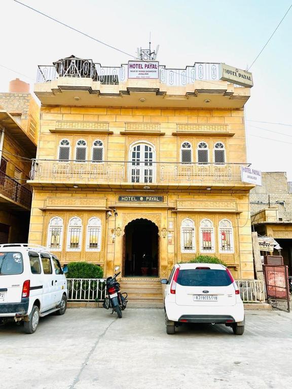 two cars parked in front of a building at Hotel Payal Jaisalmer in Jaisalmer
