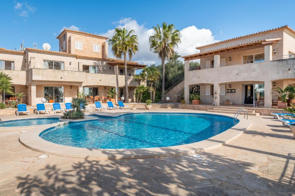 una piscina frente a una casa con palmeras en Pedrassa Gran Superior, en Cala Santanyi