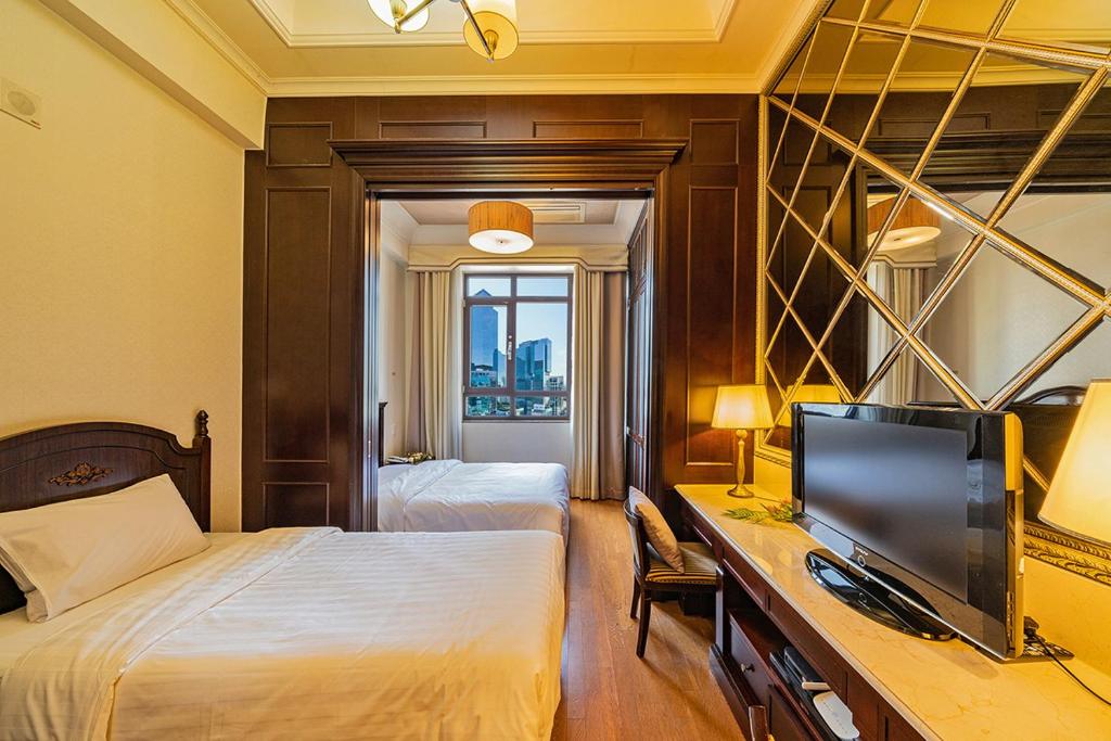 a hotel room with two beds and a desk with a television at Yeoksam Artnouveau City Hotel and Residence in Seoul