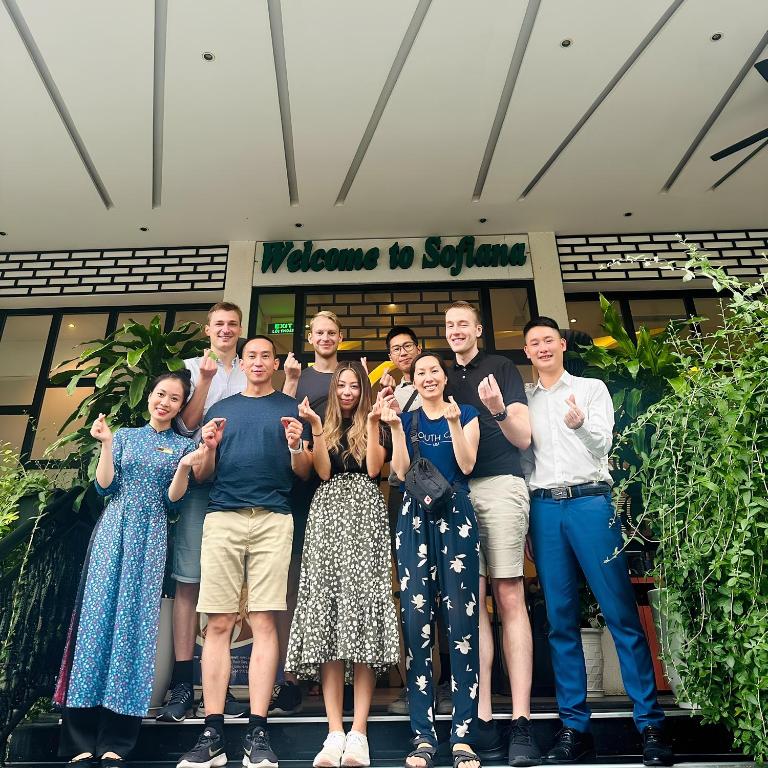 a group of people posing for a picture in front of a building at Sofiana My Khe Hotel & Spa- Rooftop Pool Bar in Danang