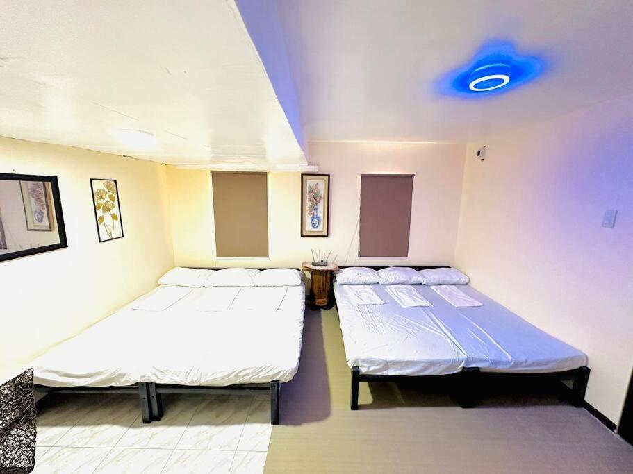 a room with two beds and a blue light at Transient House Camarines Sur Pili in Pili