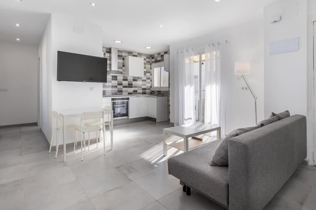 a white living room with a couch and a table at Placid Puerto in Puerto de Sagunto