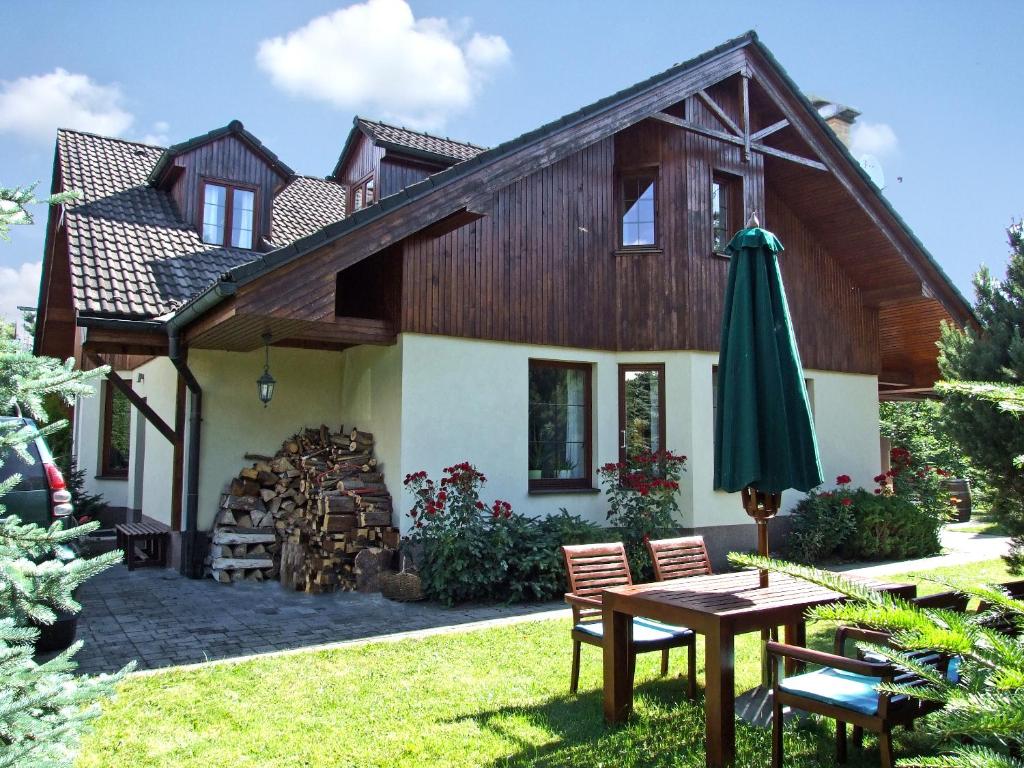 a house with a table and an umbrella at Vila Art Tatranská Lomnica in Vysoke Tatry - Tatranska Lomnica.