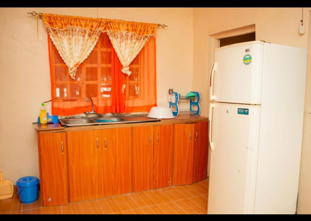 eine Küche mit einem weißen Kühlschrank und einem Fenster in der Unterkunft Airport View Homes in Eldoret