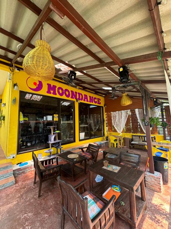 a restaurant with wooden tables and chairs and a food truck at Moondance Cottage Inn in Ko Chang