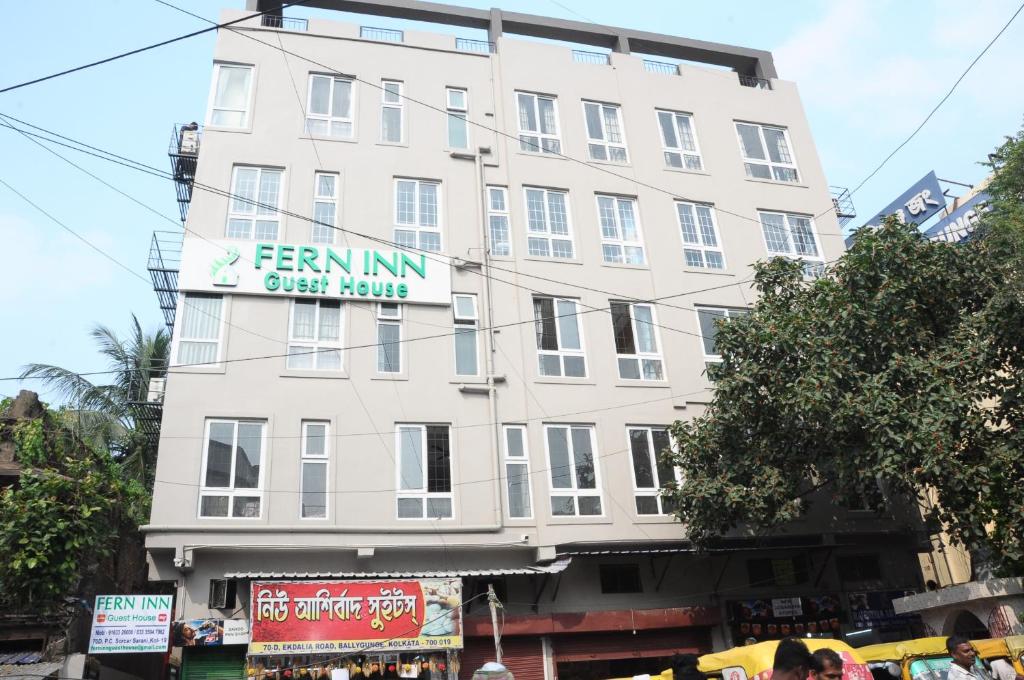 FERN INN Kolkata في كولْكاتا: مبنى أبيض طويل عليه علامة