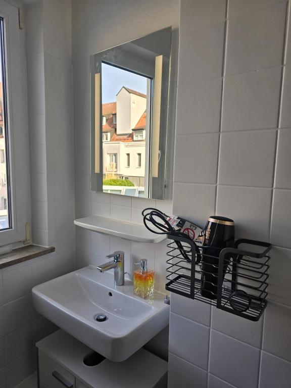 uma casa de banho branca com um lavatório e um espelho em Wohnung direkt in Zentrum em Heilbronn