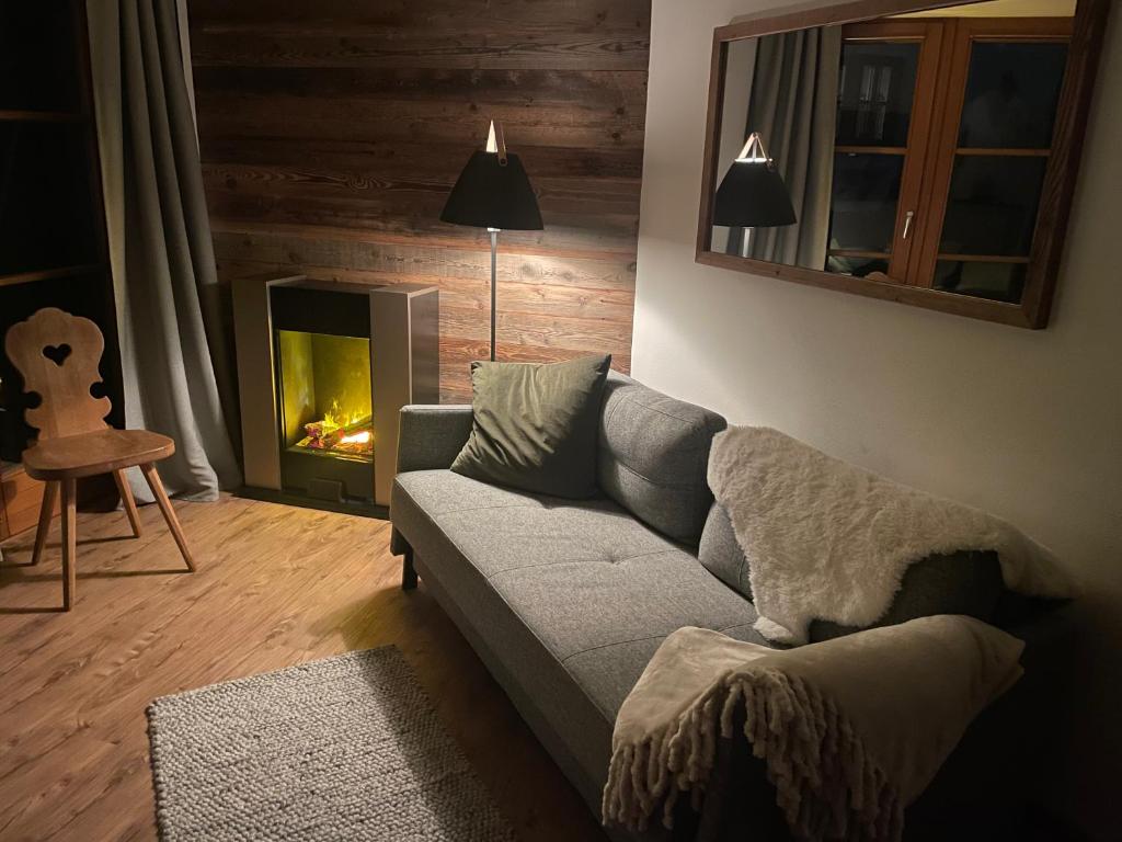 sala de estar con sofá y chimenea en Ferienwohnung Alpstadl, en Reit im Winkl