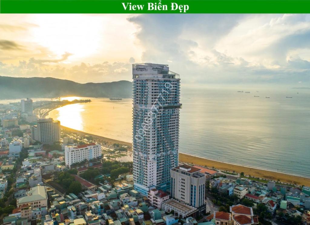 un edificio alto junto a una playa y el océano en TMS View Biển 28 Nguyễn Huệ - Quy Nhơn en Quy Nhon