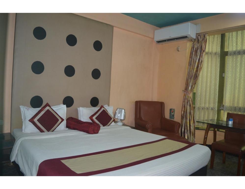um quarto com uma grande cama branca com almofadas em Hotel Aadhar, Barbil, Odisha em Bada Barabīl