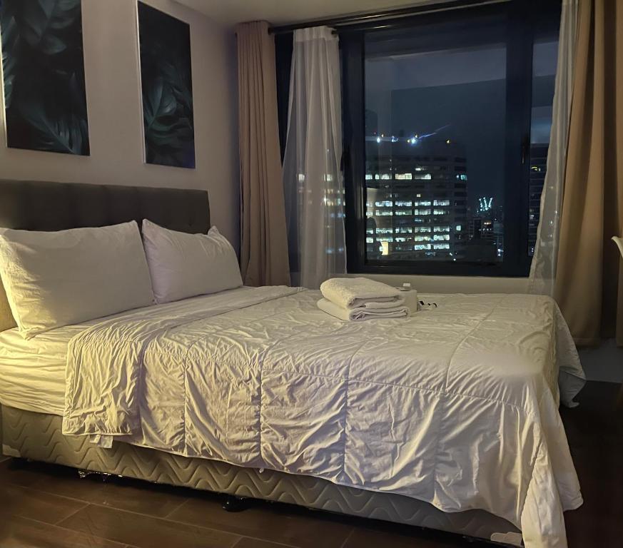 1 dormitorio con 1 cama y ventana con vistas al perfil urbano en Destina @Air Residences Makati, Metro Manila, en Manila