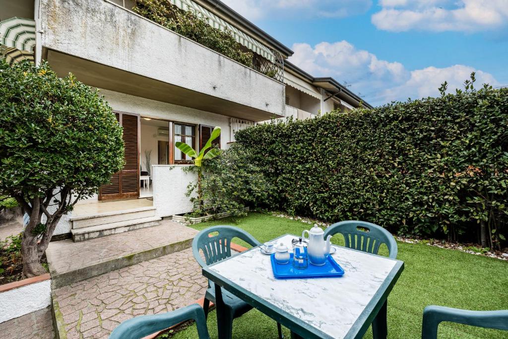 einen Tisch und Stühle im Hof eines Hauses in der Unterkunft Casa al Ponte dei Marmi - few KM to sea - Happy Rentals in Seravezza