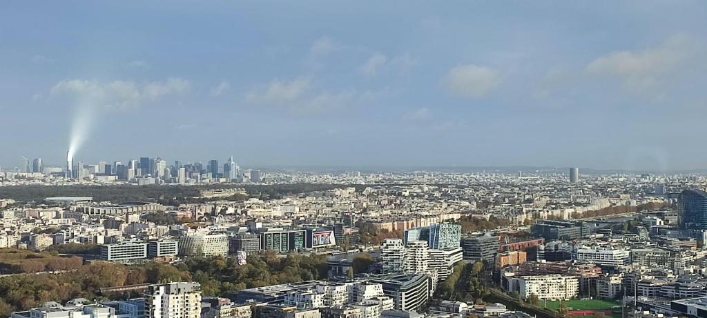 a view of a city with a rainbow in the sky at Full apt - Top floor - Eiffel Tower Panoramic View in Issy-les-Moulineaux