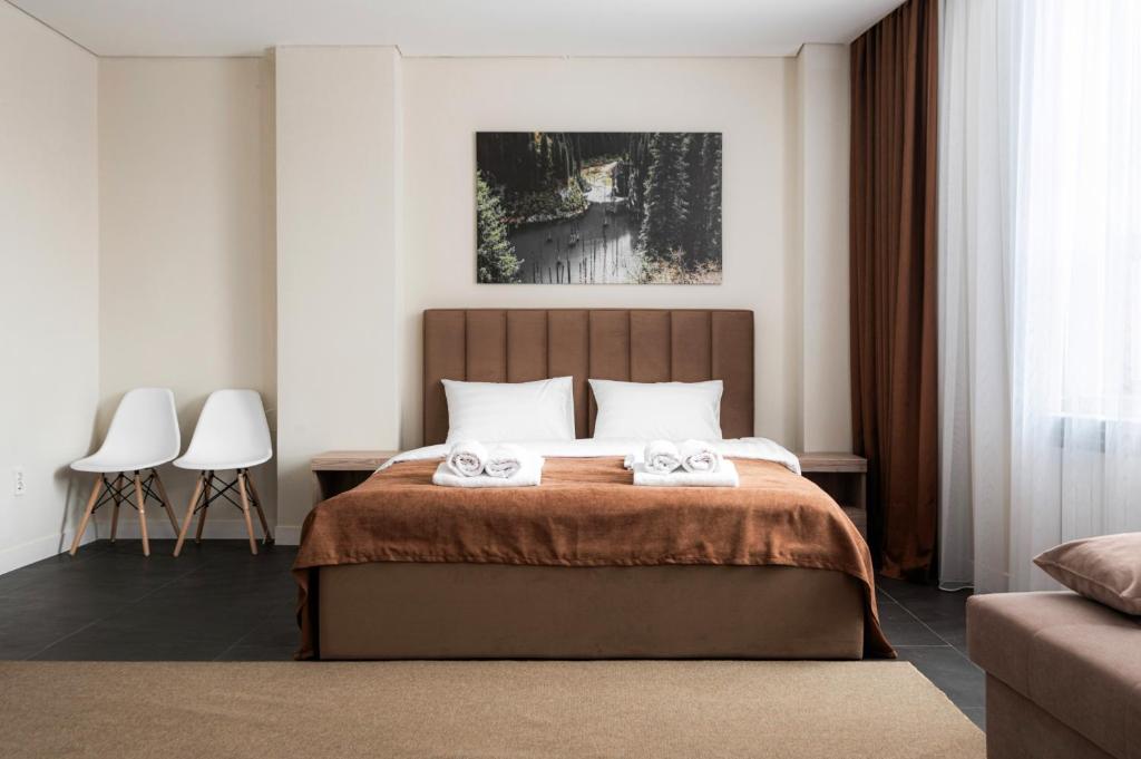 um quarto com uma cama com duas toalhas em HIGHVIL APARTAMENTS em Astana