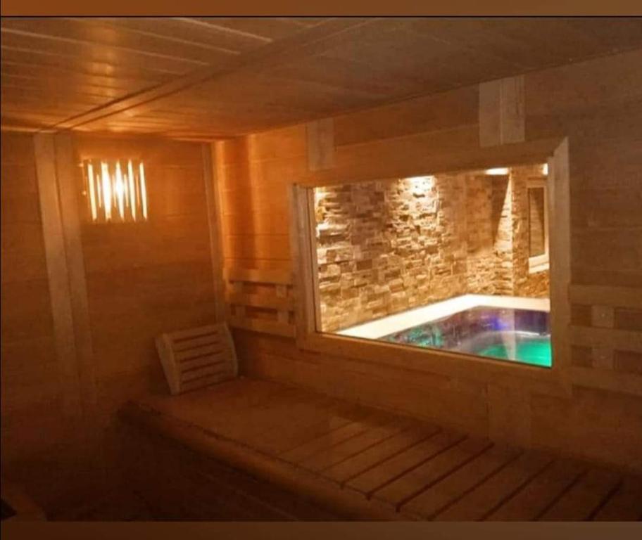a sauna with a window and a tub in it at Hotel Orso Grigio in Carisolo