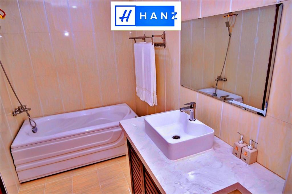 La salle de bains est pourvue d'un lavabo, d'une baignoire et d'un miroir. dans l'établissement Bao Long Hotel, à Hô-Chi-Minh-Ville