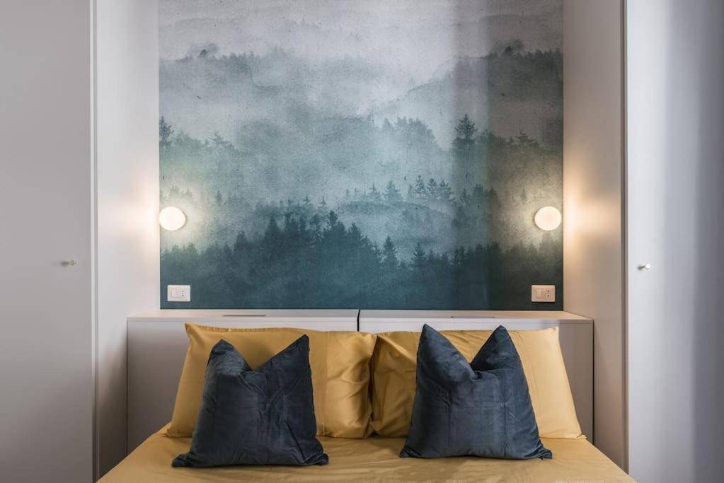 a bed with two pillows and a painting above it at La Casina 348 in Rome