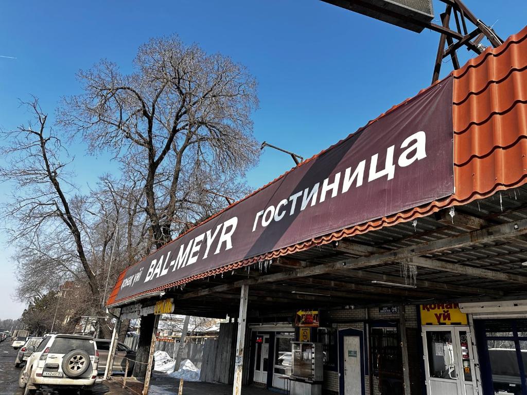 a building with a sign for a car dealership at Гостиничный комплекс Bal-Meyir in Almaty