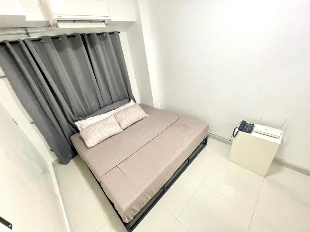 een klein bed in een kamer met een raam bij Signa Designer Residences in Manilla