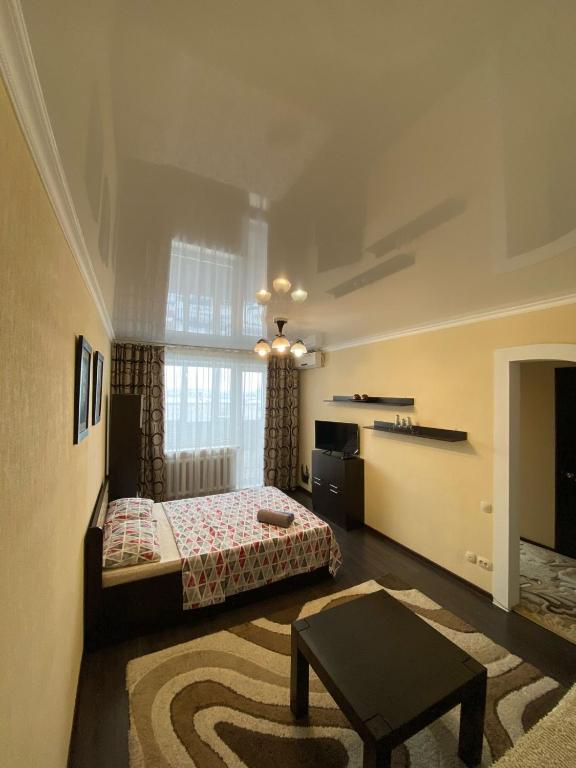 1 dormitorio con 1 cama y 1 mesa en una habitación en RIO en Petropavlovsk