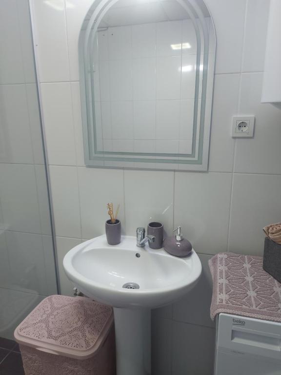 ein Badezimmer mit einem weißen Waschbecken und einem Spiegel in der Unterkunft Apartment Kjara in Ohrid