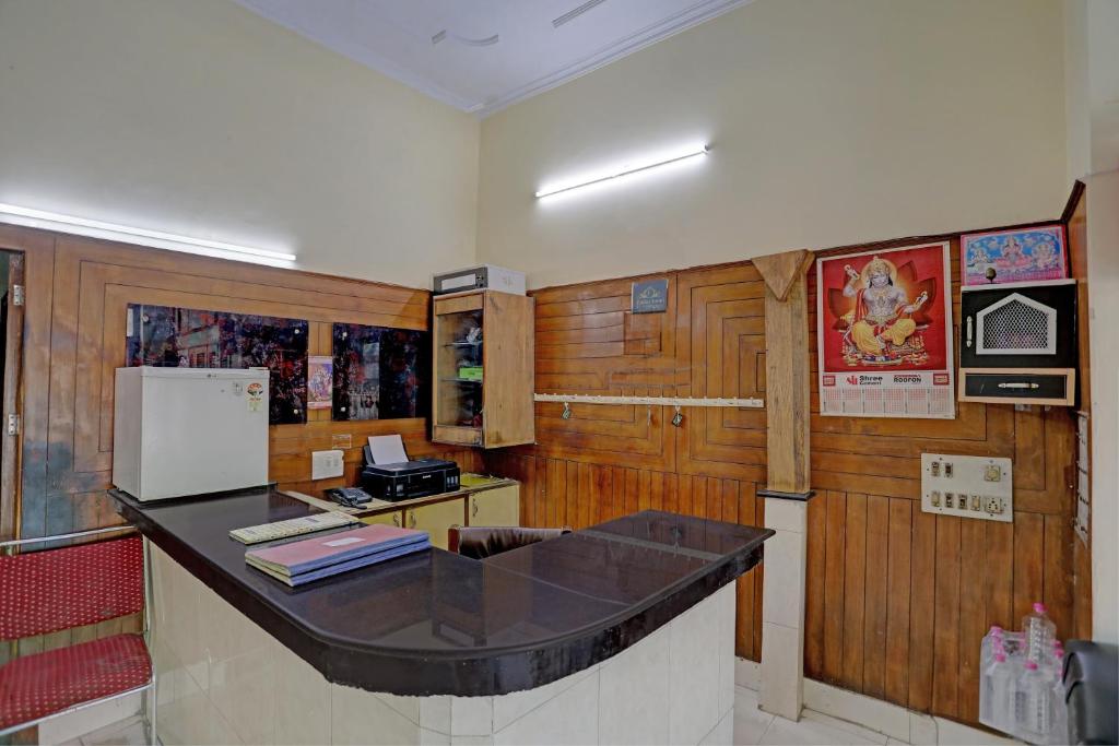 eine Küche mit Holzwänden und einer Theke mit einem Kühlschrank in der Unterkunft OYO Hotel Friday's in Bathinda
