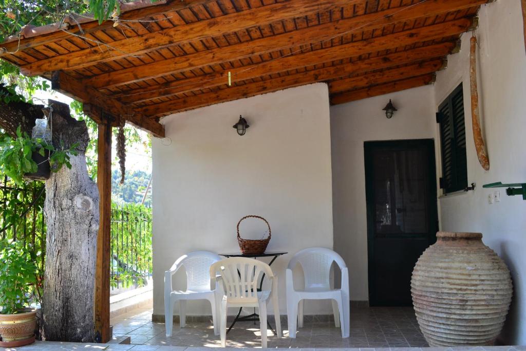 um pátio com 2 cadeiras, uma mesa e um vaso em Quiet Agricultural Guesthouse em Komílion