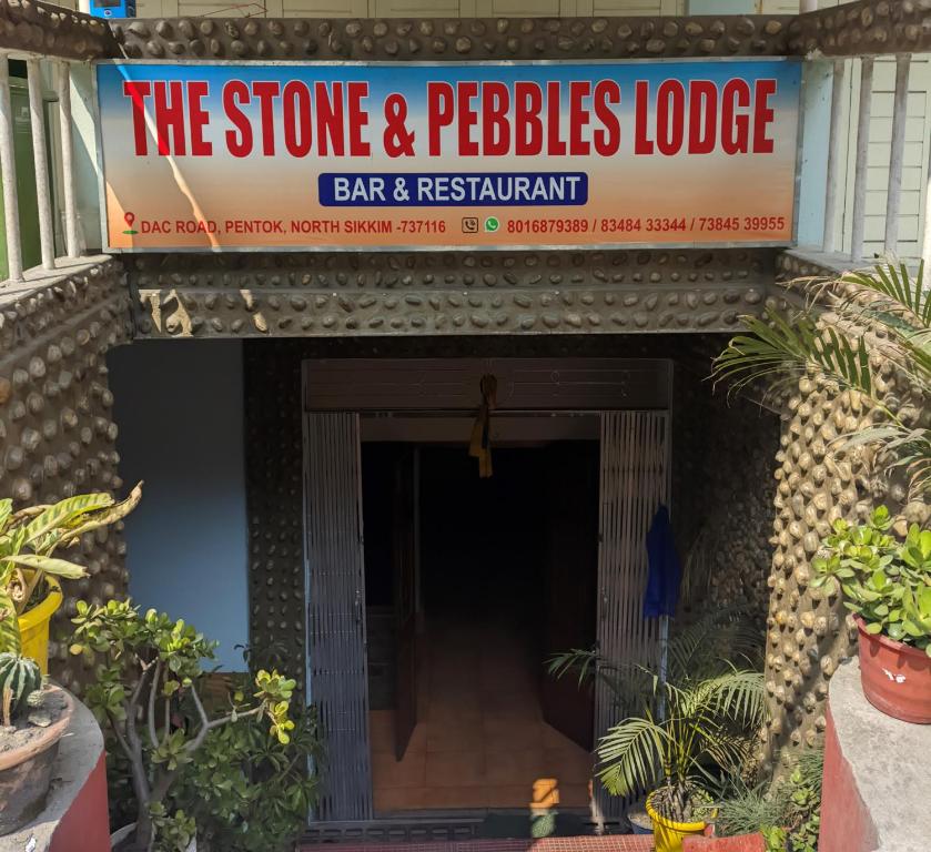 una señal para un bar y restaurante con plantas en Mangan Stone Pebbles Lodge, en Mangan