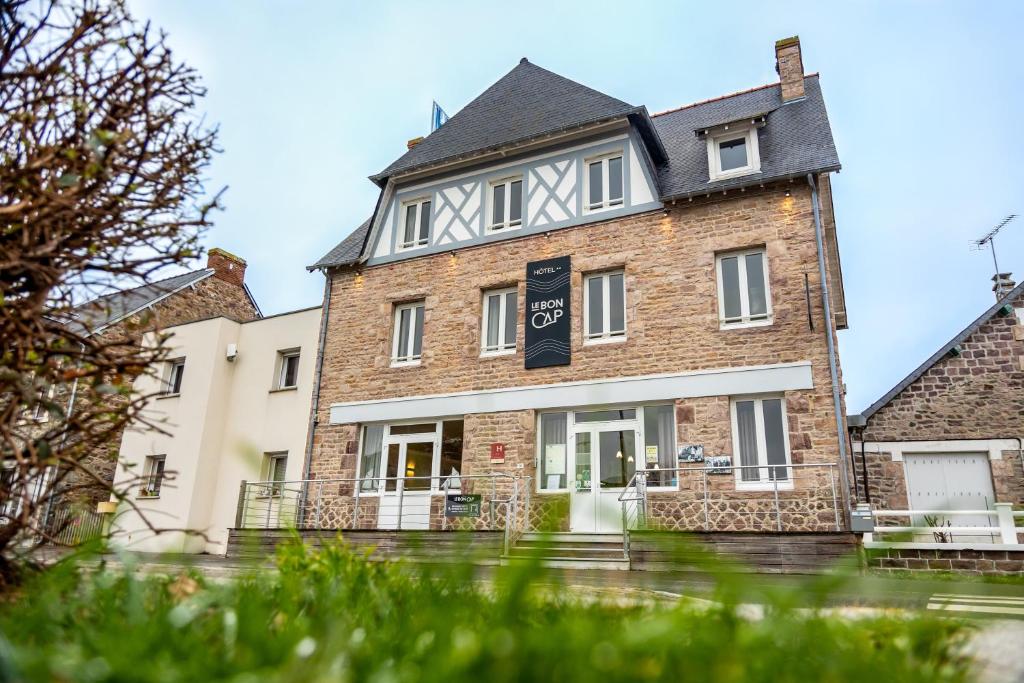 een groot bakstenen gebouw met een bord erop bij Le Bon Cap in Plurien