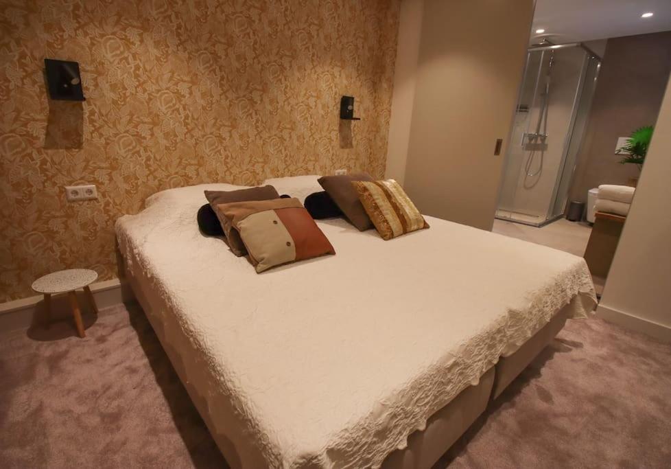 Un dormitorio con una cama grande con almohadas. en Volendam Lakeside Retreat - 20 min from Amsterdam, en Volendam